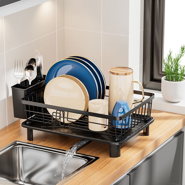 SPOORYYO Dish Drying Rack, a space-saving black iron dish rack measuring 14.9''L x 11''W x 5.1''H, positioned on a kitchen counter. It includes a removable utensil holder, plate rack, and an inclined drainboard system for efficient water drainage into the sink. Ideal for kitchen organization, it holds plates, cups, and utensils securely, with a built-in towel rod for quick drying.