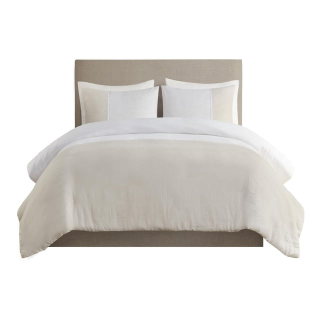 Beautyrest Mika 3 Piece Gauze Oversized Duvet Cover Set featuring a lightweight, two-tone neutral duvet cover with textured gauze fabric, hidden button closure, and matching oversized shams on a beige upholstered headboard, suitable for a casual and elegant bedroom style.