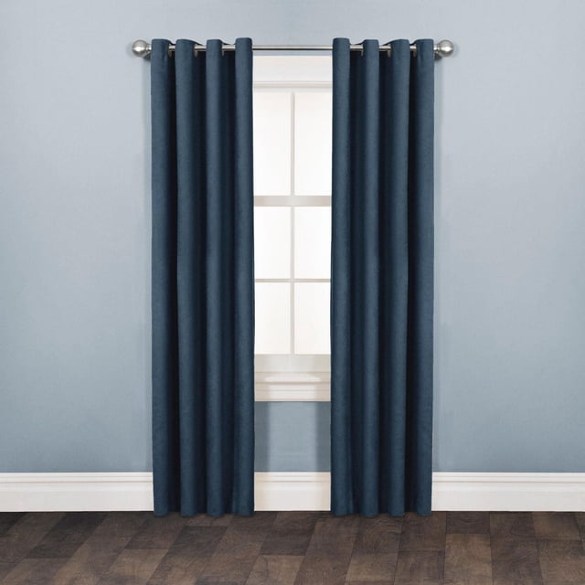 Mainstays Faux Suede Drapery Grommet Window Curtains Panel in dark blue with soft suede texture and matte finish, hanging on a silver grommet rod over a white-framed window against a light blue wall and dark wood floor, ideal for room darkening and easy installation.