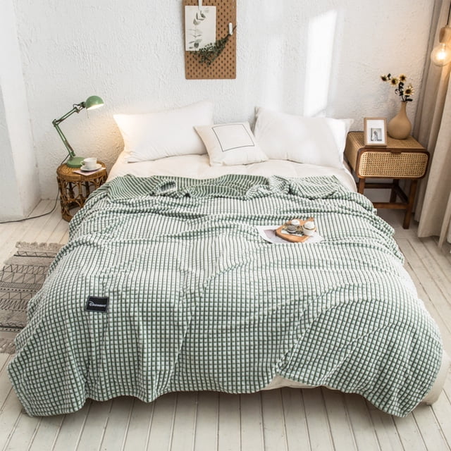Dvkptbk Woolen Blanket Multifunctional Cover Blanket Napping Blanket Flannel Blanket, displayed in a green checkered pattern, draped over a bed in a cozy, minimalist bedroom. Made from double-sided velvet, this throw blanket offers premium softness, warmth, and breathability for all-season bedding. Perfect for naps, reading, or lounging, it is machine washable and resistant to fading or pilling.