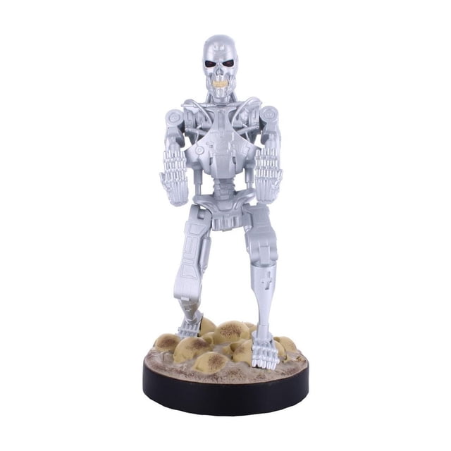Exquisite Gaming Terminator T-800 Support de Câble pour Téléphone et Manette Montrant une Figurine Robotique Argentée Orientée vers l'Avant avec des Membres Mécaniques Détaillés Debout sur une base Ronde Texturée avec des Crânes et de la Saleté, Conçue pour Tenir des Manettes de Jeu et des Téléphones Mobiles, Convient Aussi pour Organiser de Petits Articles de Bureau.