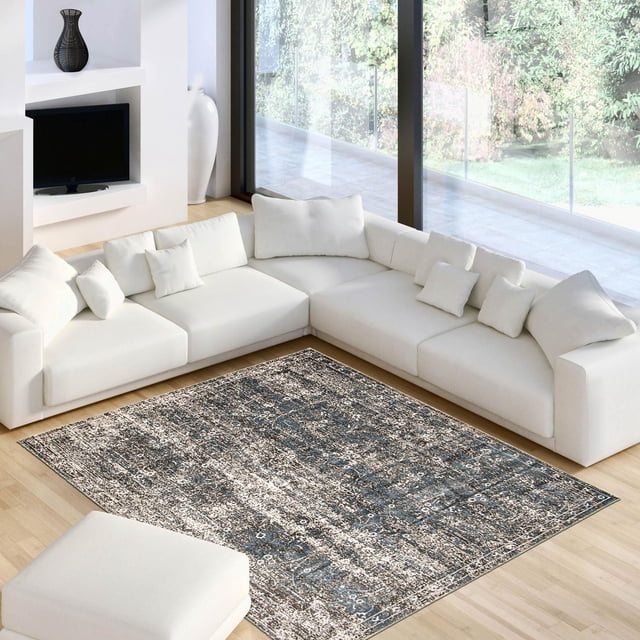 ECARPET Isla Blue, Grey Rug featuring a textured abstract blue and grey design, placed on light hardwood flooring in a bright living room with a white L-shaped sectional sofa and ottoman, suitable for enhancing accent decor spaces.