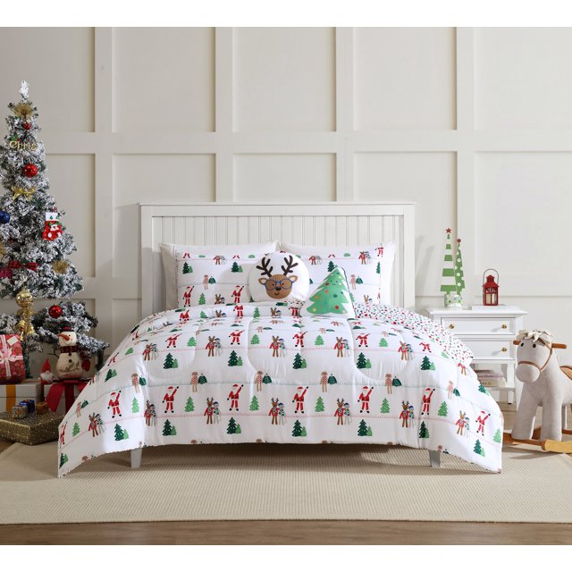 Twin bedding set with holiday-themed comforter and pillowcases decorated with Santa Claus, reindeer wearing glasses, Christmas trees, and candy canes in a cozy room with a decorated Christmas tree and toys.