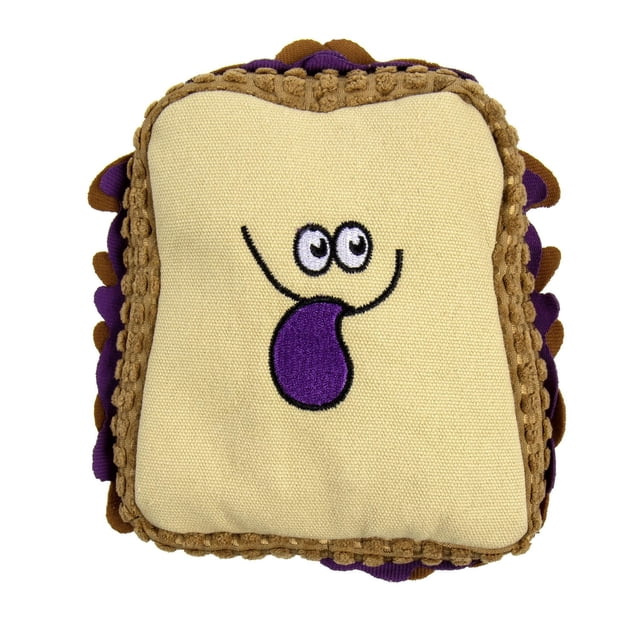 TrustyPup PBJ Plush Dog Toy shaped like a square sandwich with beige fabric front embroidered with cartoon eyes and a purple tongue, bordered by textured brown and purple plush layers simulating peanut butter and jelly, made with chew-resistant lining for durable play and cuddling.