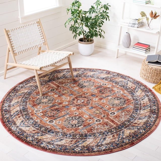 SAFAVIEH Bijar Pavel Traditional Area Rug round with Kurdish-style Persian motifs in rich earth tones and vibrant blue highlights, placed on light hardwood flooring beside a woven white chair and a green potted plant in a bright, minimalist room, often used to enhance classic or urban-chic décor.