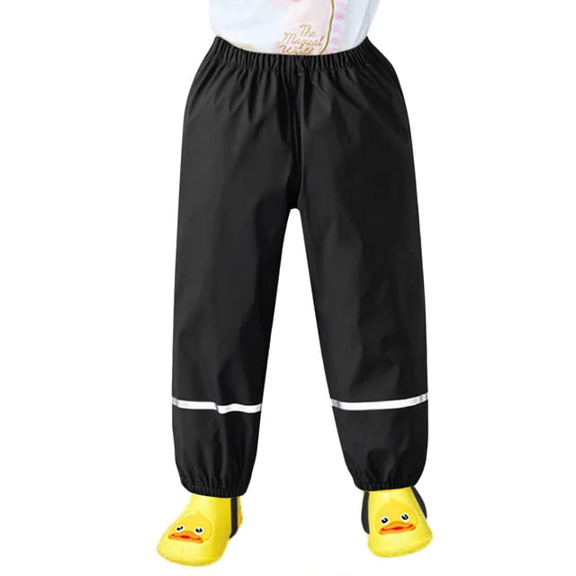 Pantalon de Neige pour Enfants, Pantalon Imperméable et Coupe-Vent en Matériau polyester durable, Montré en Noir avec Taille Élastique et accents Réfléchissants Près des Poignets. Idéal pour les sports d'Hiver comme le Ski et les Jeux Extérieurs par Temps de Pluie, de Boue et par Temps Froid, Offrant une Respirabilité Accrue et des Coutures Renforcées pour la Durabilité.
