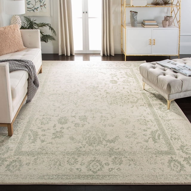 SAFAVIEH Adirondack Wyatt Tapis Traditionnel Mettant en Vedette un Motif floral Sourdine Surteint en beige et Vert Sauge, Posé sur des Planchers de Bois Franc Sombres dans un Salon Éclatant avec un sofa Crème, un Coussin Texturé Rose, un ottoman beige Capitonné et une Armoire Blanche à Cadre Doré, Idéal pour Ajouter un style Rustique de Chalet aux Maisons Modernes.