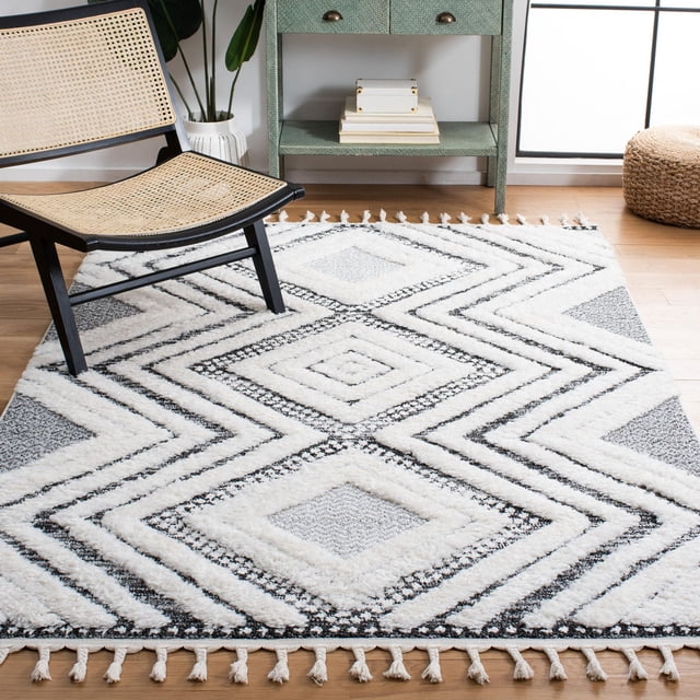 SAFAVIEH Tapis Shag Iacopo Marocain à Franges Diamant avec Motifs Géométriques Diamant Blancs et Noirs et Bords à Franges, Fabriqué en Fil Synthétique Peluche pour Confort et Durabilité, Montré sur un Plancher de Bois Clair Près d'Une Chaise Tissée et d'Une Armoire Verte, Convient à une Déco d'Accent Moderne Ou Décontractée.