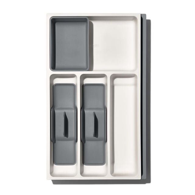 OXO Softworks Expandable Utensil Organizer with a white base and two removable gray caddies, featuring compartments for forks, knives, spoons, and irregular kitchen tools, designed for kitchen drawer organization and space-saving storage, also suitable for storing small gadgets.