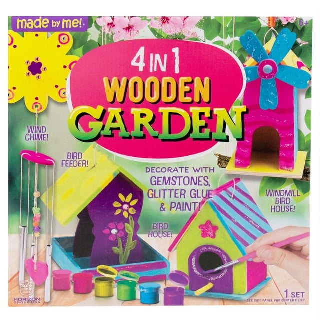 Made by Me 4-in-1 Wooden Garden Set with two miniature wooden birdhouses, a birdfeeder, and a wind chime. Includes paint, glitter glue, gemstones, and beads for decorating. A hand paints a colourful birdhouse with stripes and a star on a wooden surface with floral background, suitable for kids' arts and crafts.