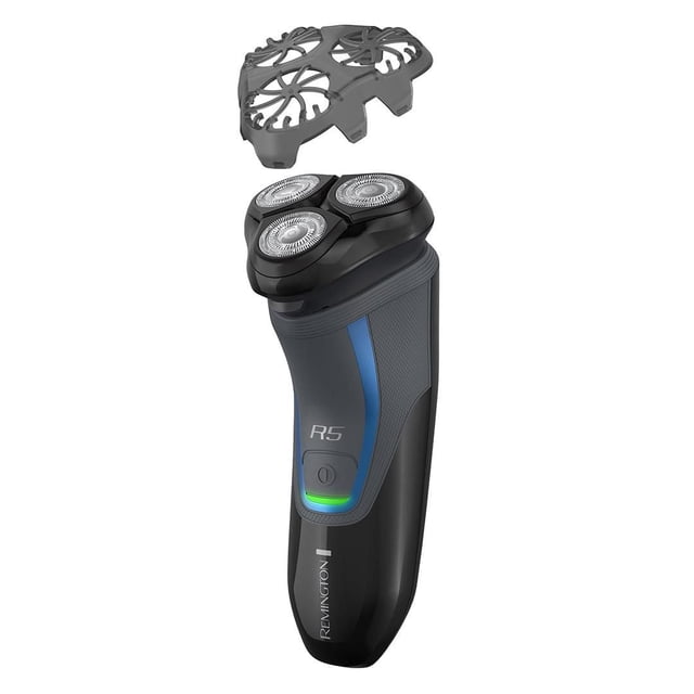 REMINGTON® R5000 Series Rotary Shaver, PR1362CDN shown front-facing with the black protective cap removed above the shaver head. It features three titanium-coated TwinTrack rotary blades on a black and dark grey body with blue accents, an R5 label, and a green-lit power button. This waterproof cordless shaver delivers up to 60 minutes runtime and includes a precision stubble attachment for versatile grooming.