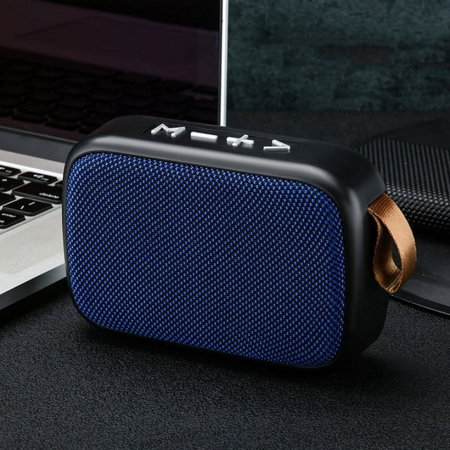 MG2 Wireless Speaker Compatible with Bluetooth Portable Waterproof Speaker for Computer Mobile Phone. A compact, rectangular wireless speaker with a textured blue front panel, black casing, and a brown strap for portability. Positioned on a desk near a laptop, showcasing its ultra-portable design, Bluetooth compatibility, and powerful bass audio quality.