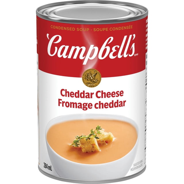 Campbell's® Condensed Cheddar Cheese Soup, Shelf Stable, 284 ml can with red and white label featuring the Campbell's logo and gold award seal, showing creamy cheddar cheese soup garnished with croutons and herbs in a white bowl, made with real cheddar and Parmesan cheeses, suitable for easy preparation or adding flavour to recipes.