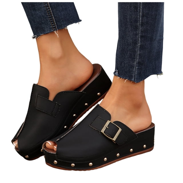 Mules Sabots à Clous pour Femmes 2025 Mode Décontractée à Bout Ouvert Plateforme Compensée à Enfiler Sandales d'Été Épaisses à Enfiler. Ces Sandales Compensées Noires Présentent un design à Bout Ouvert, des accents Cloutés le Long de la Semelle, et une Sangle à Boucle Décorative. le style à Enfiler et la Plateforme Compensée Offrent Confort et Hauteur, les Rendant Idéales pour un Usage Estival Décontracté.