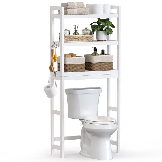 SONGMICS Over-The-Toilet Storage Bathroom Organizer Toilet Rack with Adjustable Shelf, White UBTS01WT. A white bamboo over-the-toilet storage unit featuring three shelves, four hooks, and a toilet paper holder. The middle shelf is adjustable to three heights, accommodating items like shampoo bottles or decorative plants. The bottom bar can be set at two heights to fit various toilet sizes. The unit is shown in a bathroom setting, holding towels, toiletries, and decorative items. Dimensions: 10.2 inches deep, 24.8 inches wide, and 66.9 inches high.