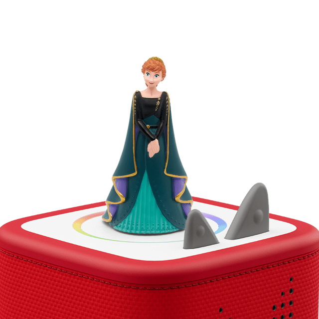 Tonies - Frozen 2/La Reine Des Neiges 2 - Anna (FRENCH ONLY) figurine in a teal and black dress with gold trim and purple cape, placed on a red Toniebox audio player with a white top and gray control knobs, designed for screen-free educational entertainment.