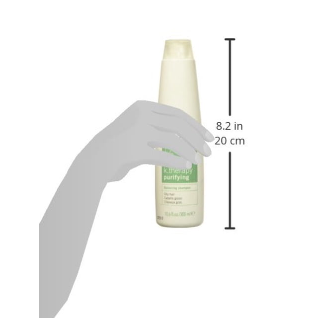 Lakme K. Therapy Purifying Balancing Shampoo in a 10.6 fl oz bottle. The shampoo is designed for oily hair and scalp, promoting balance and purification. The bottle is tall and slim with a cream-colored cap and a light green label. A hand is shown holding the bottle for scale, with the height indicated as 8.2 inches (20 cm).