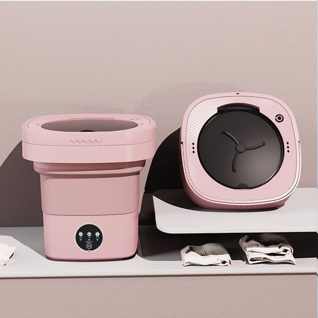 Portable Folding Washing Machine with 7L capacity shown in a pink plastic resin design. The image displays the compact washer in two configurations: fully extended for use and folded for storage. The machine features an integrated washer and spinner, suitable for small laundry loads like baby clothes. Positioned on a shelf with folded towels, it highlights its lightweight and travel-friendly design, ideal for dormitories or travel. Plug-in operation with energy-efficient functionality.