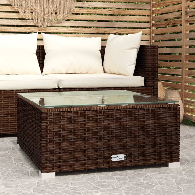 vidaXL Table Basse de Jardin Brun 60x60x30 cm en Rotin poly et Verre, au design Carré avec un Cadre Robuste en Acier Enduit de Poudre et des Pieds en Plastique Chromé. la Table a un Extérieur en Rotin PE Brun Tissé et un Dessus de Table en Verre, Convient à une Utilisation Extérieure Ou Intérieure. Présentée dans un Décor de patio avec des Meubles Assortis et un Écran d'Intimité en Bois en Arrière-Plan.