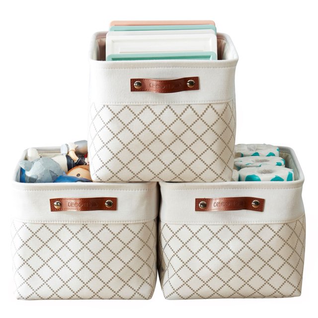 DECOMOMO 3-Packs Large Patterned Design Foldable Storage Bin with Handles displayed in a stacked arrangement. Each bin features a beige diamond-patterned fabric with faux leather handles embossed with the DECOMOMO logo. The bins are shown holding various items, including toys, diapers, and books, highlighting their multi-purpose use for organizing nurseries, closets, and offices. Dimensions of each bin are 15 inches (L) x 11 inches (W) x 9.5 inches (H).