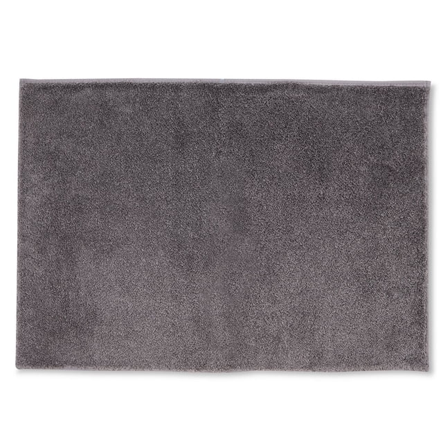 Mainstays Lotus Super Soft Bath Mats, 20" x 34", in solid dark grey with a plush polyester surface and rectangular shape, featuring a non-slip backing for secure placement on bathroom floors, suitable as a soft landing for feet.
