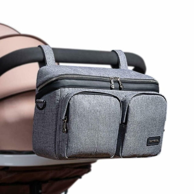 Sunveno Universal Stroller Organizer Multifunctional Storage Solution for Baby Essentials Diaper Bag in gray, attached to a stroller handle. The bag features a large capacity with multiple compartments, including two front zippered pockets and a main zippered compartment. Designed with adjustable Velcro straps for compatibility with various stroller models, it can also be used as a shoulder bag or crossbody bag. Made from moisture-proof and wear-resistant material.