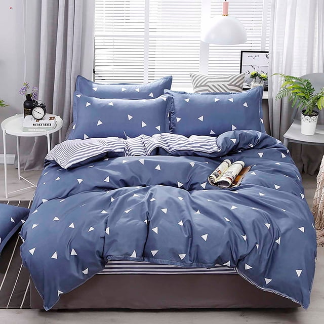 XYAIYT Soft 4 Piece Bedding Set with a reversible multicolour design, displayed on a queen-size bed. The set includes a quilt cover, fitted sheet, and two pillowcases made from breathable A-grade water-washed polyester fabric. One side features a modern triangular print, while the other has striped patterns, offering versatile style. The bedding is arranged in a bright, modern bedroom with natural light and decorative elements.