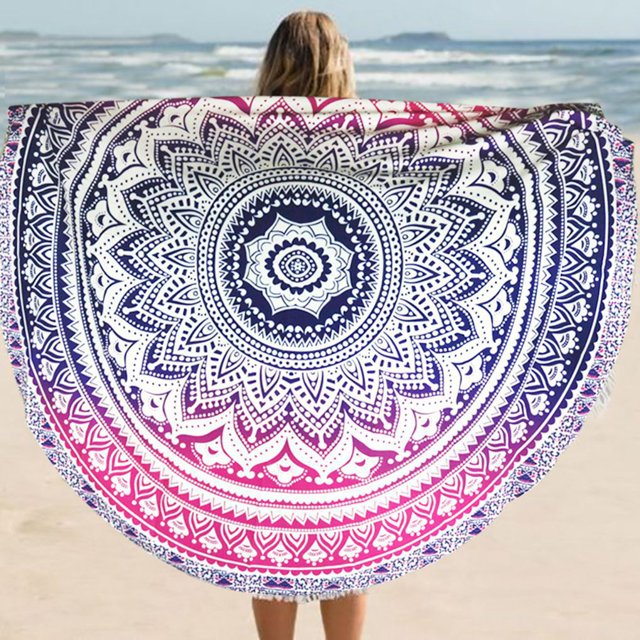 braveheart Tapis Rond à Extrémités de Couleur Fader, Nappe de Plage Ronde, Serviette de Plage d'Été, Tapis de Yoga Rond en Mousseline avec un Motif de mandala vibrant dans des Nuances de Bleu et de Rose. le Tapis Rond a un Diamètre de 150 cm et Convient comme Nappe, Couvre-Lit, Tenture, Rideau, Suspension Murale Ou Drap de Plage. l'Image Montre le Tapis Tenu sur une Plage avec l'Océan en Arrière-Plan.