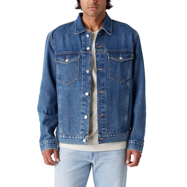 Levi Strauss Signature™ Men's Original Trucker Jacket in blue 100% cotton denim with classic trucker fit, button front closure, patch chest pockets with button flaps, and on-seam side pockets, worn over a beige shirt and light wash jeans, ideal for casual layering.