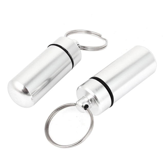 Unique Bargains 2pcs Chrome Waterproof Aluminum Pill Bottle Cache Holder Container Keychain. The image shows two silver-tone aluminum pill containers with a chrome finish, each featuring a cylindrical shape, a screw-on cap with a black O-ring for waterproof sealing, and an attached split keyring. Dimensions include an external size of 44 x 17mm (1.7 x 0.67 inches) and an inner diameter of 15mm (0.6 inches). Suitable for storing pills or small items while traveling.