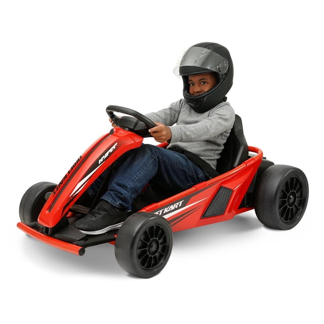 Hyper Toys 24V Drifting Go Kart Ride On for Kids in red with a child wearing a black helmet seated inside. The battery-powered ride-on features a red frame, black drift-style wheels, steering wheel, and seatbelt. It works on grass and hard surfaces with three speed settings and forward/reverse control.