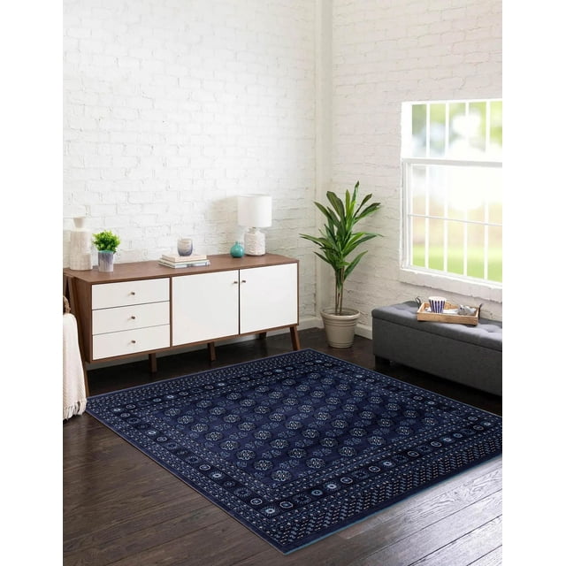 Tekke Oriental Area Rug for Living Room, Dining Room, Bedroom in a bright room with dark hardwood floors. The rug features a navy blue base with symmetrical oval and diamond-shaped motifs in lighter blue and white, framed by traditional patterned borders. Positioned under a wooden sideboard with white drawers and doors, beside a potted green plant and a gray bench with a tray holding a cup and teapot. Known for its soft pile and classic design, this rug is suitable for adding traditional elegance to living spaces and as a decorative accent in bedrooms or dining rooms.