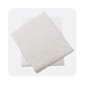 Beige and white polka dot sheet set folded on white background.