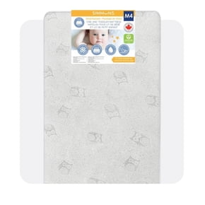 The image shows a crib and toddler mattress. The mattress is light grey with a subtle pattern featuring small, outlined animal faces, possibly owls, scattered across its surface. At the top of the mattress, there is a label with the brand name "SIMMONS" and the model "M4." The label includes an image of a baby, several icons indicating features such as breathability, water resistance, and comfort, and a Canadian flag symbol, suggesting it is made in Canada. The label is bilingual, with both English and French text. The mattress is rectangular with rounded corners, designed for