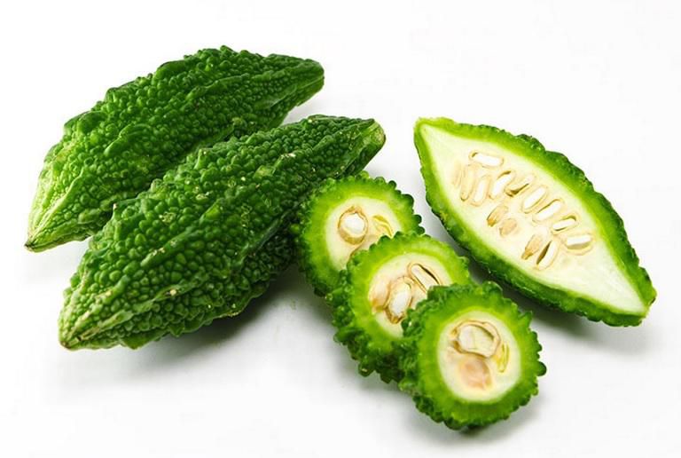 Karella (Bitter Gourd), Sold in singles, 0.20 - 0.90 KG A centered front-facing close-up of one karella (bitter gourd) vegetable with elongated, ridged bumpy green skin and short stem on a white background, shown whole and suitable for slicing for stir-fry or curried dishes; often used for pickling.